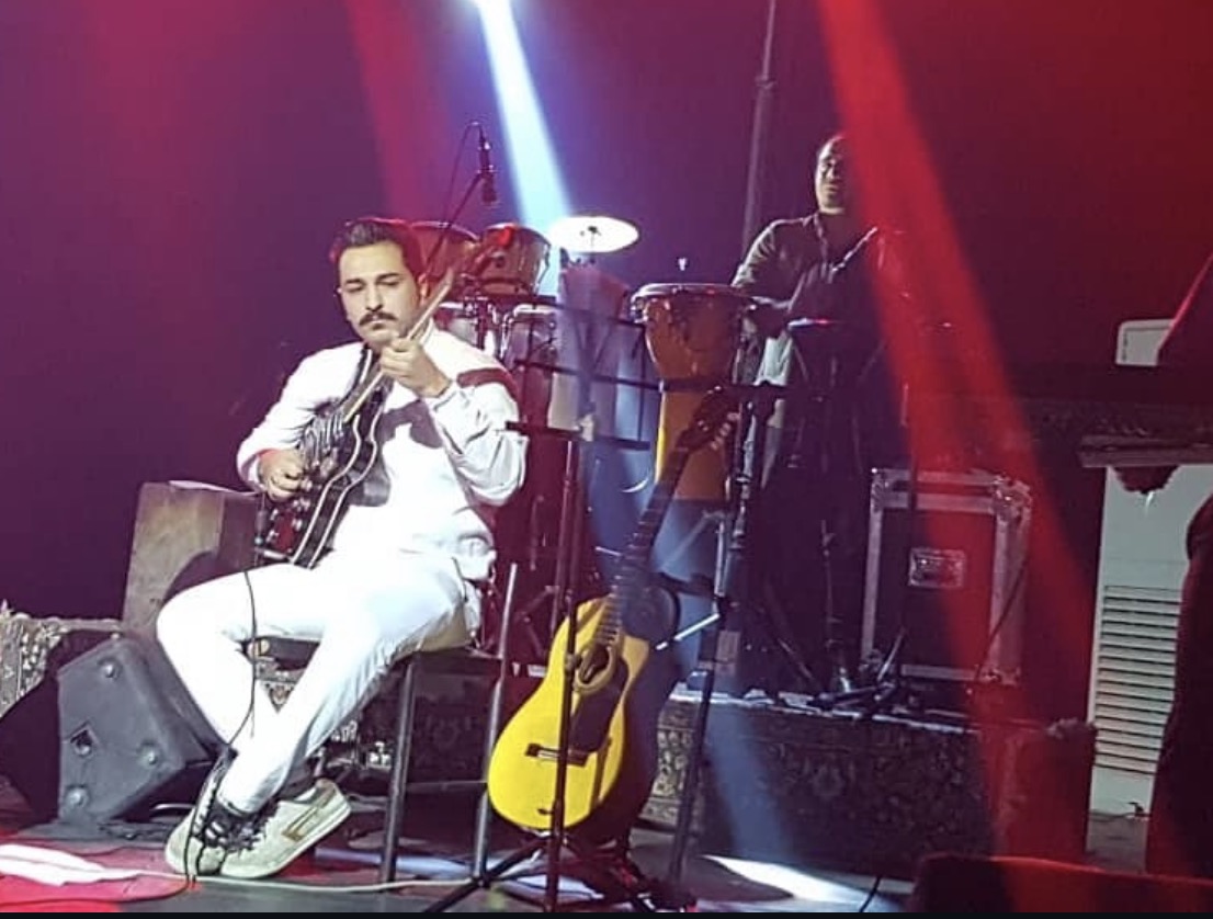 Bobby Azad performing worship music on acoustic guitar